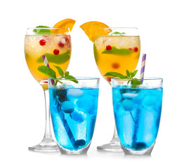 Glasses of cold cocktails on color background