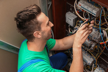 Electrician installing alarm system in distribution board