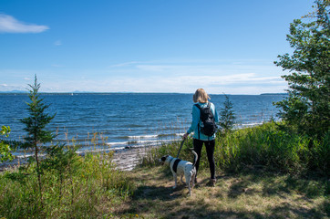 woman with dog next to lake