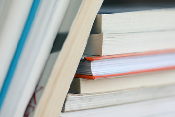 A stack of book leaning on a pile of books, artistically arranged, beautiful copy space.