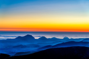 Fototapeta na wymiar Silhouetted Hills, Setting Sun over Ocean