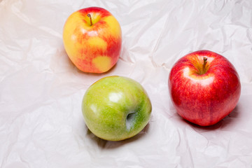 3 yellow red and green apples on crumbled paper.  Healthy snacks