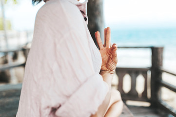 Young woman meditating in a yoga pose at the beach