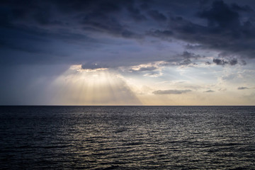 Fototapeta na wymiar Sunset rays shining over the ocean