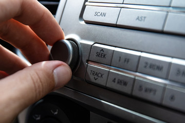 the driver turns the volume knob in the car