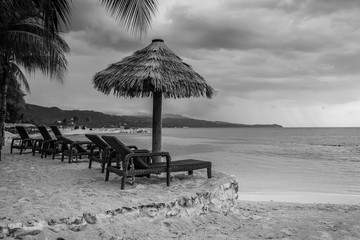 beach with chairs and grass umbrellas