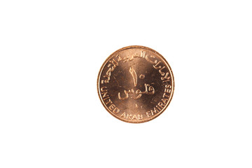 A ten fils coin from the United Arab Emirates isolated against a white background