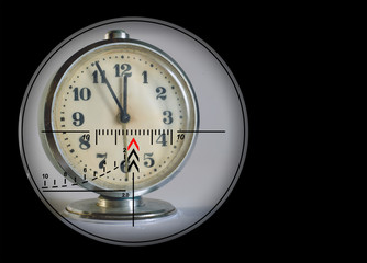 Under the sight of a sniper rifle old alarm clock showing the time. The concept of killing personal...