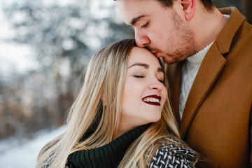 happy young couple walking through the park on a snowy day