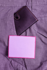 Small little wallet inside man trousers front pocket near notation paper