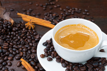 Coffee cups and coffee beanson wood background.