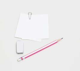blank white paper with paperclip, pencil and eraser