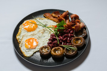 Bacon and eggs served with beans and mushrooms