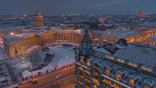 The central point of the city: traffic and people of Nevsky Prospect, Kazan Cathedral and Singer House in winter evening in St. Petersburg