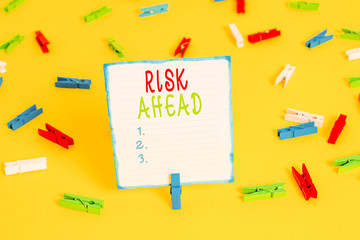 Handwriting text Risk Ahead. Conceptual photo A probability or threat of damage, injury, liability, loss Colored clothespin papers empty reminder yellow floor background office