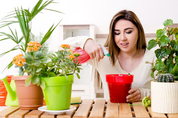 Young female gardener with plants indoors