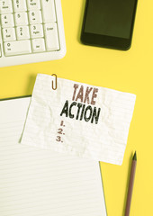 Text sign showing Take Action. Business photo text to do somethingoract in order to get a particular result Crumpled white paper on table with paper clips clock mobile and pc keyboard