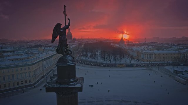 Angel of the Alexander Column in a snowy winter sunset with a flying drone near above Palace Square, shooting the Admiralty, Saint Isaac's Cathedral in Saint Petersburg, Russia