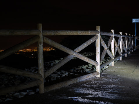 barandilla de madera en v&iacute;a pecuaria con luces de la ciudad de alicante en el fondo