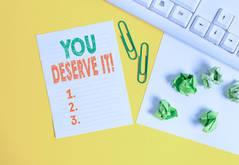 Conceptual hand writing showing You Deserve It. Concept meaning should have it because of their qualities or actions Flat lay with copy space white paper with paper clips on the table