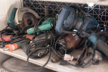 Many old electric drills on shelves in the workshop