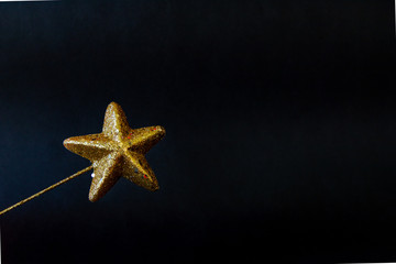 Christmas golden star magiс wand with glitter isolated closeup on black background, template for...