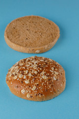 Rye bun empty isolated. American food classic rye round burger bread isolated on a blue background. Grilled burger bun top.