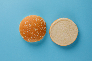 Burger bun empty isolated. American food classic round burger bread isolated on a blue background....
