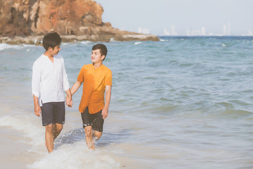 Homosexual portrait young asian couple walking with cheerful together on beach in summer, asia gay going tourism for leisure and relax with happiness in vacation at sea, LGBT legal concept.