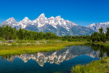 Obraz na płótnie Canvas The Tetons reflected in the Snake River at Schwabacher Landing in Grand Teton National Park, Wyoming