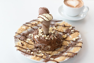 Delicious pancakes with ice cream, sweet syrup, pieces of chocolate, coconut shavings and cup of coffee with heart shape.