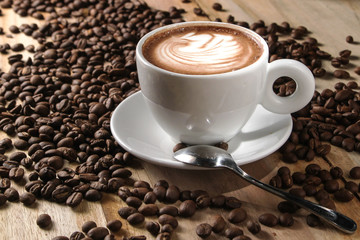 cup of coffee and beans on wooden background