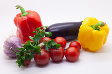 Vegetables, tomatoes, bell peppers, eggplant, garlic and parsley on a white background, selective focus