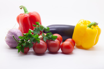 Vegetables, tomatoes, bell peppers, eggplant, garlic and parsley on a white background, selective focus