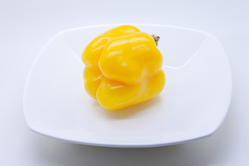 Yellow sweet bell pepper on a white plate ,  selective focus