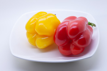 Red and yellow sweet bell pepper on a white background, selective focus