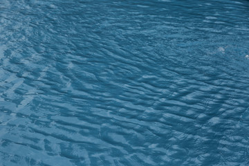 Blue swimming pool edge with refection of water ripple