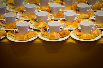 Row of croissants, cakes and a cup of coffee