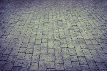 Road made of small pieces of old gray bright stone