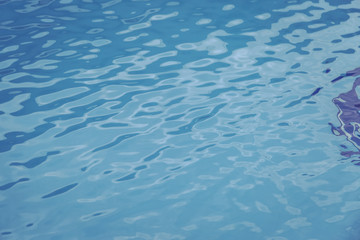 Blue swimming pool edge with refection of water ripple