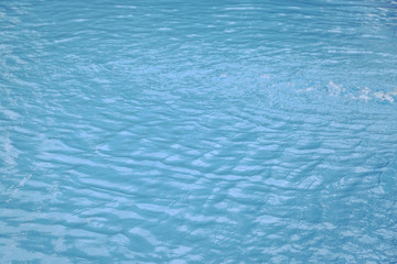 Blue swimming pool edge with refection of water ripple