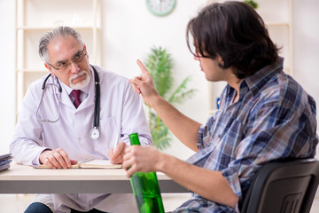 Obraz premium Young male alcoholic visiting old doctor