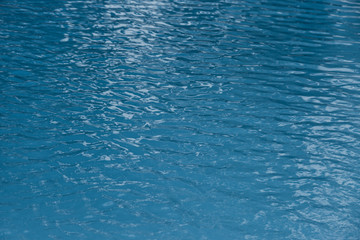 Blue swimming pool edge with refection of water ripple