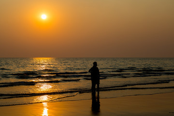 Siluate lovers and beach before sunset