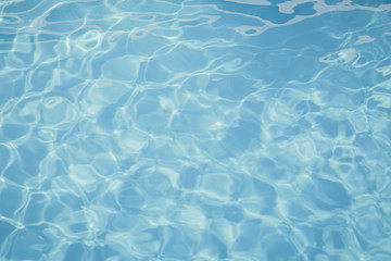 Blue pool water with sun reflections