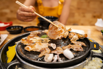 hands using chopsticks to grilled pork barbecue