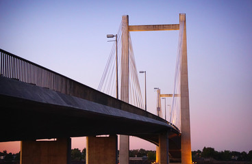 Obraz premium Cable suspension bridge over river at dusk
