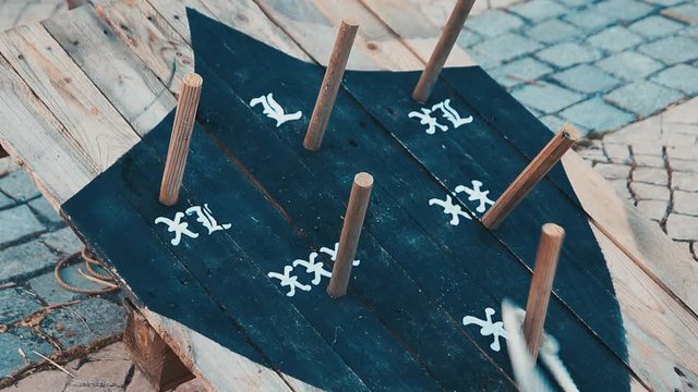 Medieval outdoor entertainment wooden game middle ages involves the throwing of metal, rope or rubber rings over a set distance, usually to land over or near a spike called a hob, mott or pin.