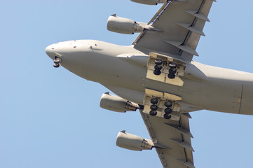 Naklejka na ściany i meble Military transport plane viewed from under at an airshow