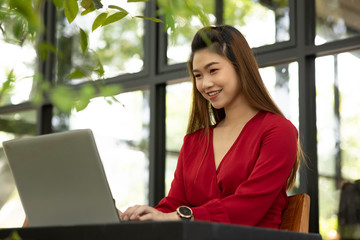 Obraz na płótnie Canvas Beautiful Attractive Asian woman wearing red dress working with computer laptop and thinking to get ideas and requirement in Business startup feeling so happiness,Business Startup Concept